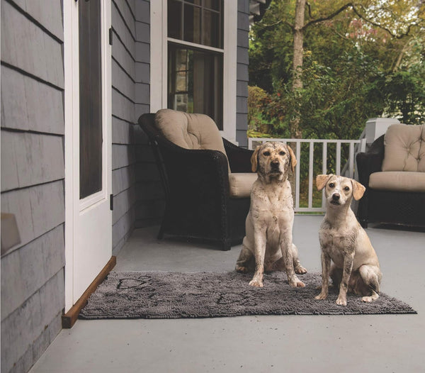 An image of the Dirty Dog Door Mat runner with two dirty dogs sitting on it, highlighting its effectiveness in trapping dirt and mud.