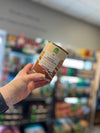 Hand holding a can of Open Farm Homestead Chicken Pâté, highlighting the product's label and ethical sourcing promise.
