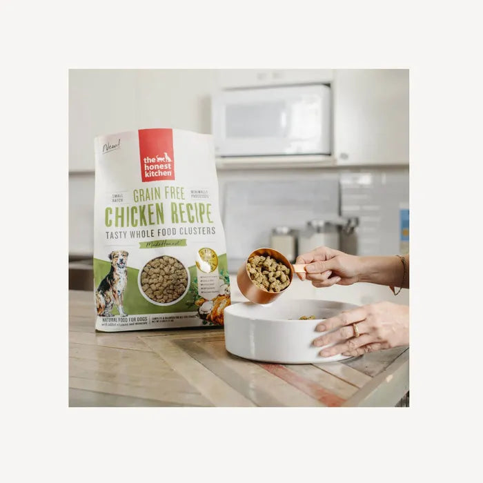 A pet owner scooping out The Honest Kitchen Whole Food Clusters - Grain Free Chicken, ready for serving.