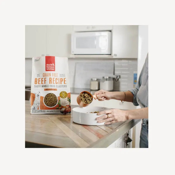 Dog owner scooping out The Honest Kitchen Whole Food Clusters - Grain Free Beef, ready to serve.