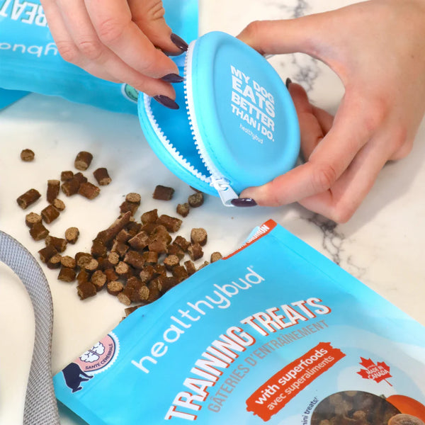 A person placing treats into a treat pouch, demonstrating their perfect size for training on the go.