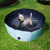 Image of the Goo-Eez pool placed on grass with a small white dog inside enjoying the water, showing how it keeps pets cool and playful outdoors during hot days.