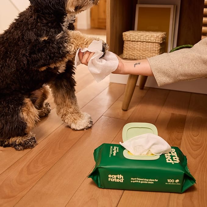 A dog's paws being gently wiped with Earth Rated Unscented Compostable Wipes, showcasing their effective cleaning action and gentle touch.