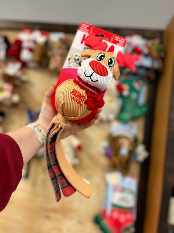 Kong Holiday Wubba toys featuring Christmas-themed characters (reindeer) with soft plush, long tails for tugging, and a festive plaid design for interactive play and cozy snuggles.