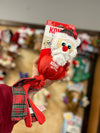 Kong Holiday Wubba toys featuring Christmas-themed characters (Santa) with soft plush, long tails for tugging, and a festive plaid design for interactive play and cozy snuggles.