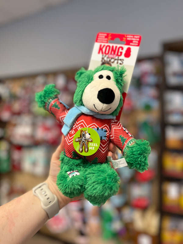 Kong Holiday Wild Knots Bear Green medium/large dog toy featuring festive winter sweater and scarf, with durable knotted rope inside and squeaker for interactive play and snuggling