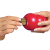 Image of a hand placing a KONG Ziggie into a KONG Classic toy, demonstrating how the chew can be used to enrich playtime while promoting oral hygiene.